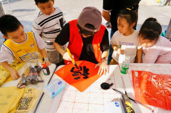 实践团成员带领孩子们学写“福”字。重庆电力高等专科学校经济管理学院供图